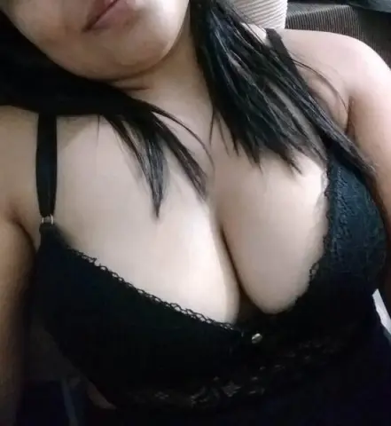 Woman in black lace lingerie relaxing indoors with a moody, intimate aesthetic.
