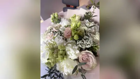 BlairBlanche shows off a large, beautiful bouquet of white and pink roses with green foliage.