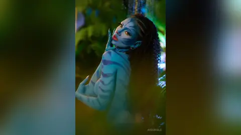Ethereal Na'vi woman with blue skin and tribal markings posing in a lush, mystical jungle setting.