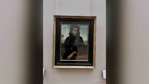 Classic portrait painting of a man in dark vintage attire hanging on a white gallery wall.