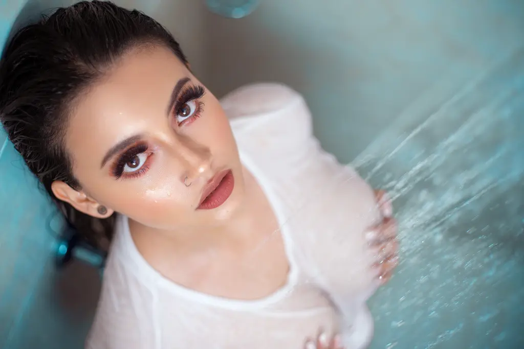 IsabelaJohnson — IsabelaJohnson looks up while water splashes over her wet hair and white mesh top.