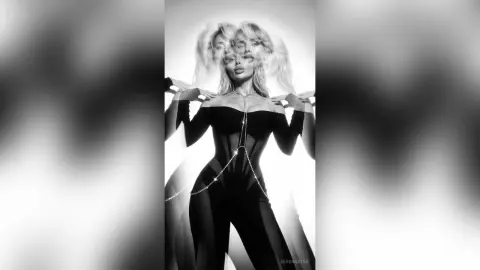 SerenaStar poses in a black bodysuit against a bright white background, showing her blonde hair and cleavage.