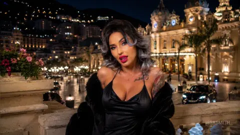 Glamorous woman in a black satin dress and fur coat posing at night in Monte Carlo.