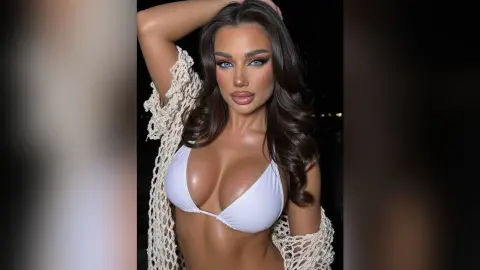 Beautiful brunette woman in a white bikini and crochet cover-up posing outdoors at night.