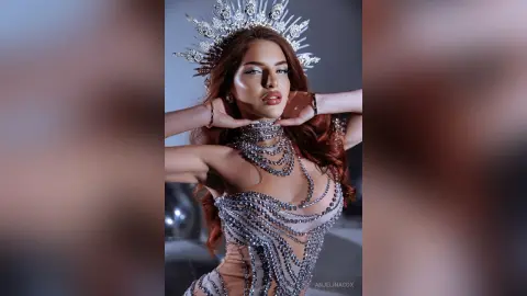 Glamorous woman in a sparkling silver sequin gown and crystal crown posing with an elegant, regal mood.