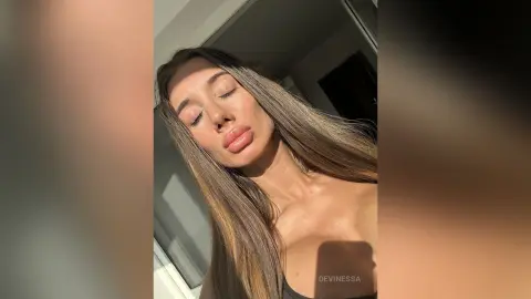 DeviNessa tilts her head back, showing her long brown hair and face in warm sunlight.