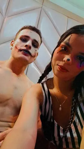 Darly_AndDixon and her partner pose together, wearing clown-style face paint and a black and white striped tank top.