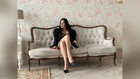 TessaWinsent — TessaWinsent sits on a white vintage sofa wearing a black blazer and black lace lingerie.