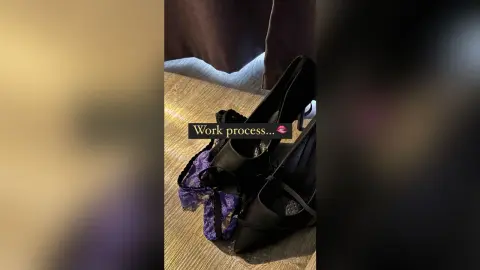 Elegant black high heel pumps and purple lace lingerie laid on a wooden surface for a fashion work process.