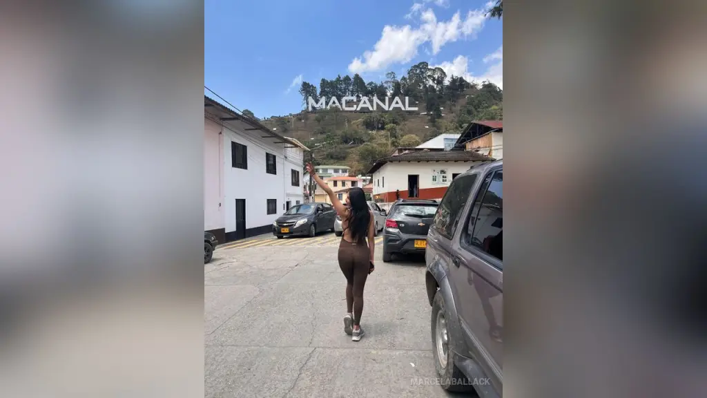 MarcelaBallack — Woman in brown yoga set standing on a street in Macanal under a bright blue sky.