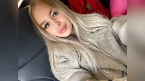 Blonde woman in a cozy beige shearling jacket relaxing in a car with a soft, casual mood.