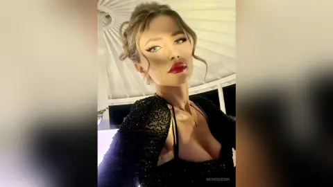 Glamorous woman in a black sequin evening dress posing with elegant makeup in a bright indoor setting.