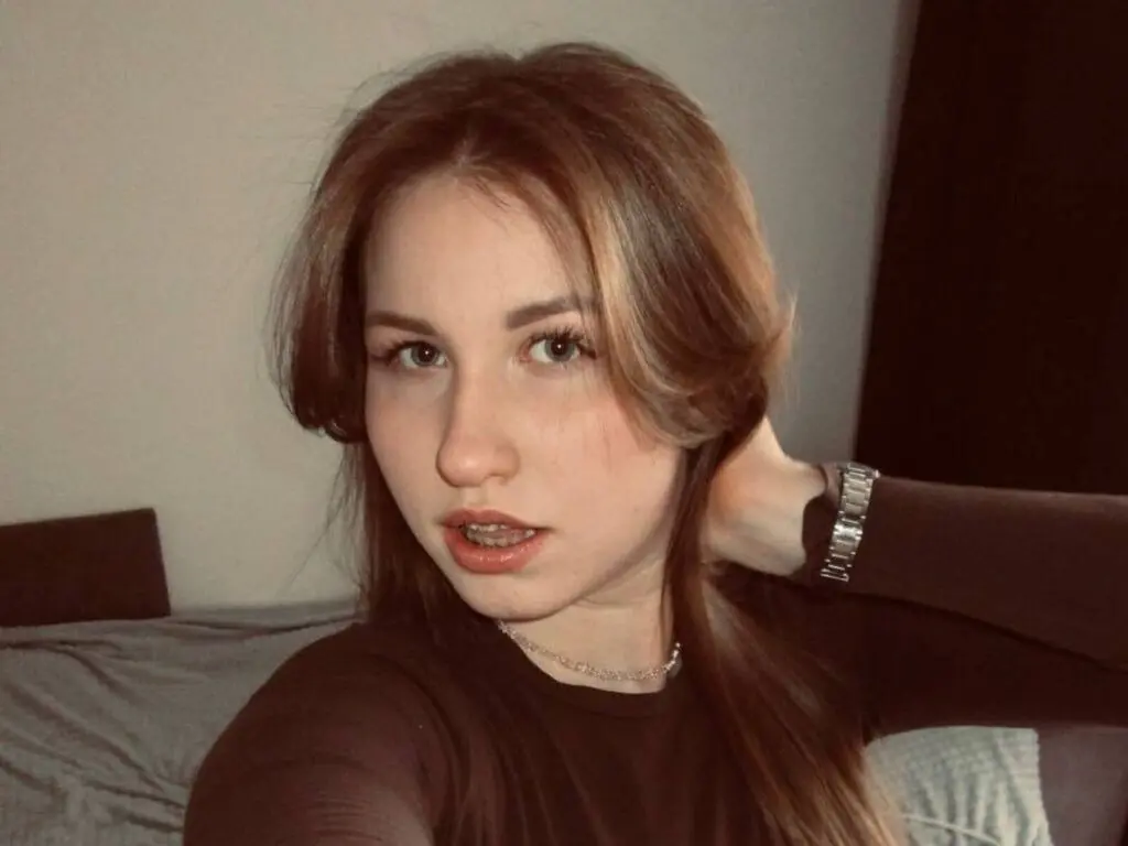 MargaritaHafele poses with her hand behind her head, wearing a dark long-sleeve top and a silver necklace or choker.