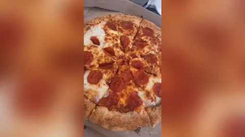 Delicious pepperoni pizza with melted cheese in a cardboard delivery box ready to eat.