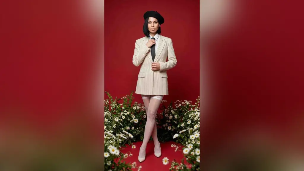 SandraBex — Elegant woman in a beige blazer, black tie, and beret posing amidst white flowers against a red background.