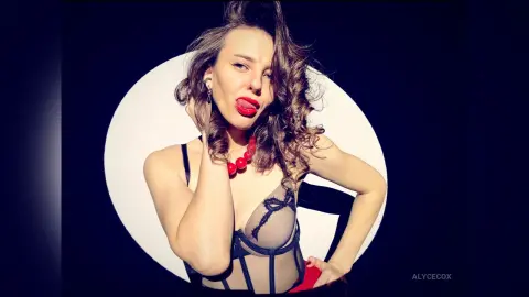 Glamorous woman in black lace lingerie and red necklace posing against a bright circular studio backdrop.