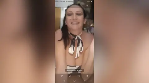 Smiling woman in a black and white halter neck top posing indoors for a casual selfie.