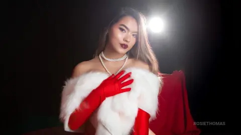 RosieThomas — Glamorous woman in red gloves and white faux fur wrap posing against a dark studio background.