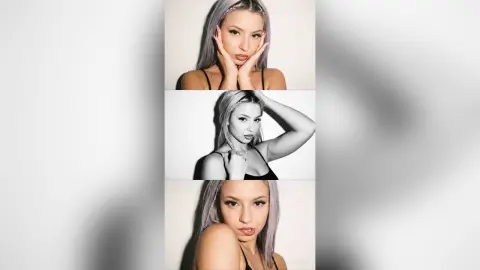 Kalira poses with her hands against her face, showing her long light-colored hair and wearing a black camisole top.