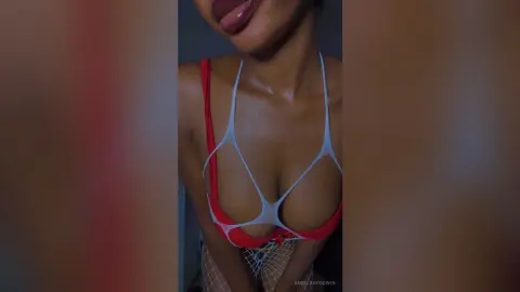 AngelaGoodwin wears a red bra and white string detail, showing off her wet, shiny skin and dark hair.