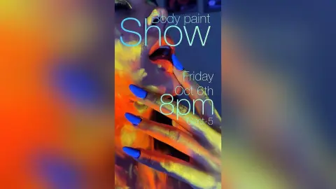 Artistic body paint model with blue nails posing for a creative night event under colorful studio lighting.