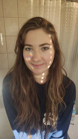 jenellehayesxoxo looks into the camera with a soft smile, wearing a silver choker against her skin.