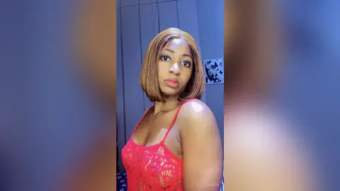 JoanJon poses in a red lace tank top with her blonde hair styled in a bob.