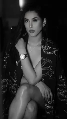Elegant woman in a patterned silk robe posing in a moody, black and white portrait.