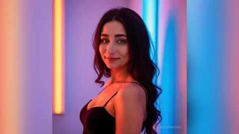 Beautiful woman in a black camisole posing against colorful neon studio lights with a moody atmosphere.