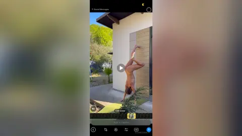Fit man performing a challenging yoga pose outdoors in a sunny garden setting.