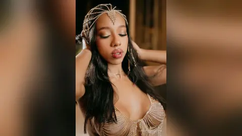 Elegant woman in a gold beaded bodysuit and jeweled headpiece posing with a glamorous, ethereal mood.