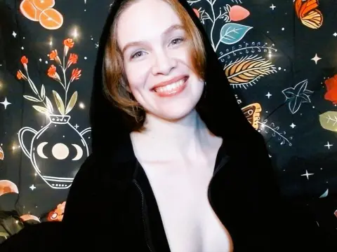 ChillBillie smiles in a black hooded sweatshirt against a dark floral patterned background.