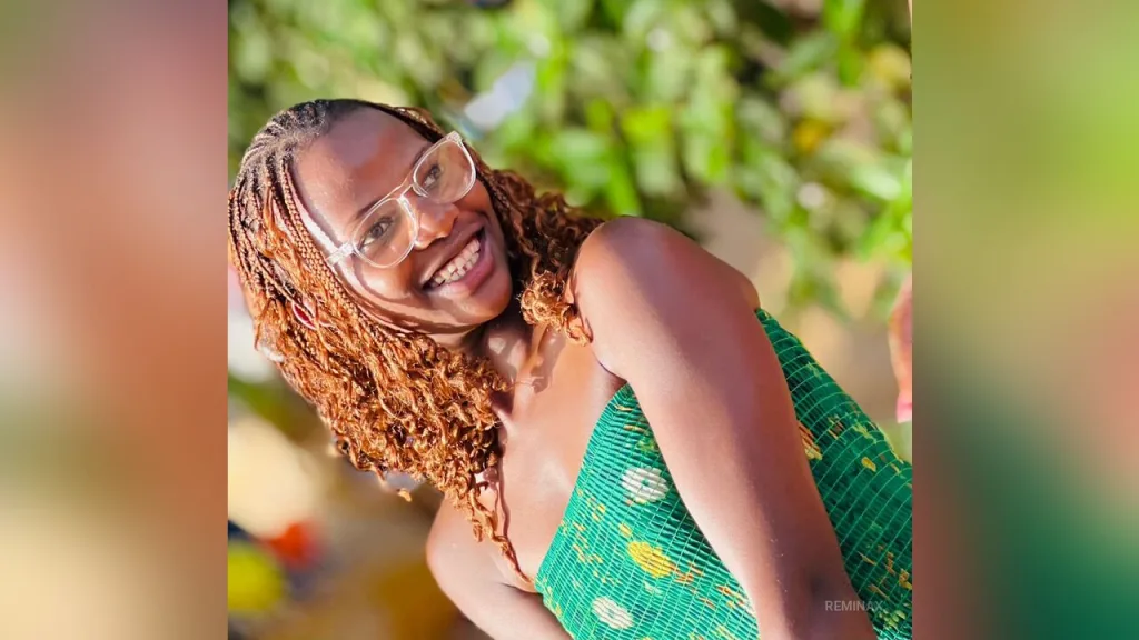 RemiNax — RemiNax smiles wearing glasses and a green patterned tube top while posing outdoors.