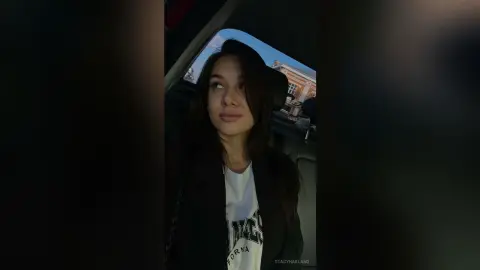 StacyHarland — StacyHarland looks toward the side while wearing a black jacket over a white t-shirt inside a car.