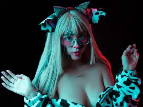 Blonde woman in cow print fuzzy outfit and ears posing playfully under teal neon lighting.