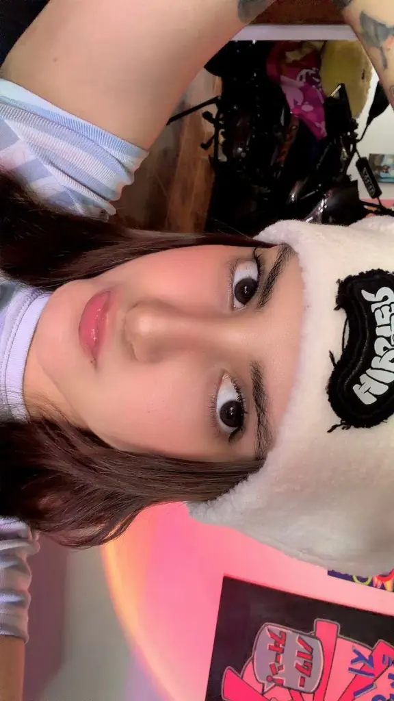 ChaeyoungDe poses with a close-up headshot, showing her dark wavy hair and black-rimmed glasses while wearing a black top.