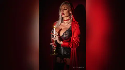 LeslyAnderson poses in black lace lingerie and a red silk robe while holding a lit candle near her chest.