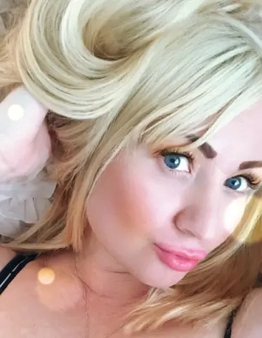 TenderLora poses close-up with her blonde hair swept to the side, showing her blue eyes and pink lips.