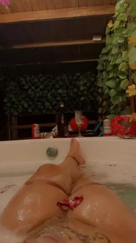 bigtits00022 poses naked in a white bathtub filled with water, showing her bare pussy and wet skin while leaning back against the tub edge.