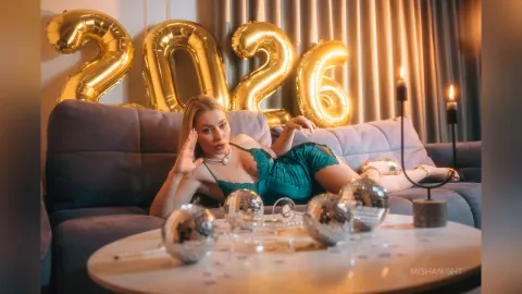 MishaNight — MishaNight reclines on a grey sofa in a teal lace bodysuit, surrounded by gold balloons and disco balls.
