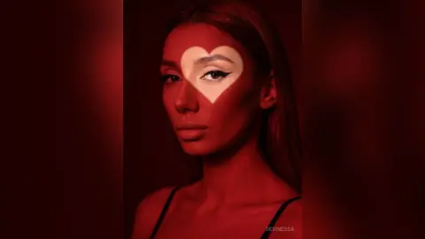 DeviNessa poses with a heart-shaped light shadow cast over her face and eyes.