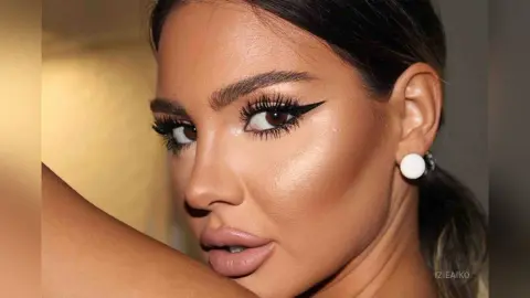 IzieAiko looks directly at the camera with heavy winged eyeliner, full lips, and a side-parted hairstyle, wearing white stud earrings.