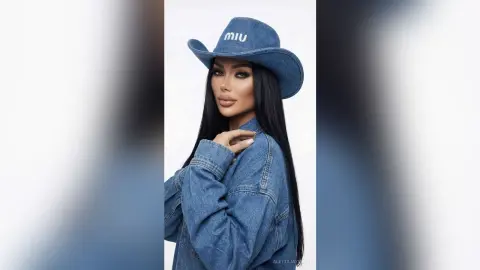 Glamorous woman in a blue denim jacket and Miu cowboy hat posing against a clean white background.