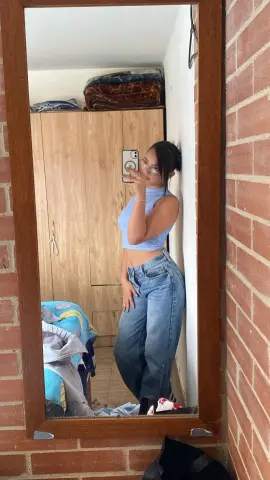 Katalinax_Rose takes a mirror selfie wearing a light blue crop top and blue jeans.