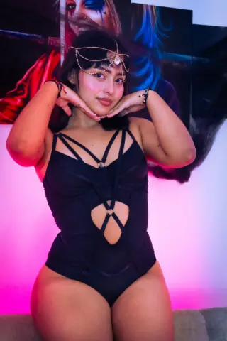 Young woman in a black cutout bodysuit posing confidently against a colorful artistic background.