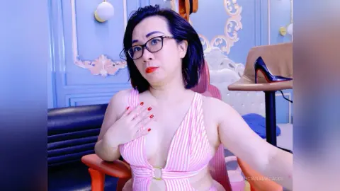 Woman in pink striped bikini top wearing glasses in a blue vintage style room.