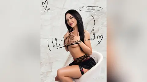Beautiful woman in black lace lingerie sitting against a white textured background with a playful mood.