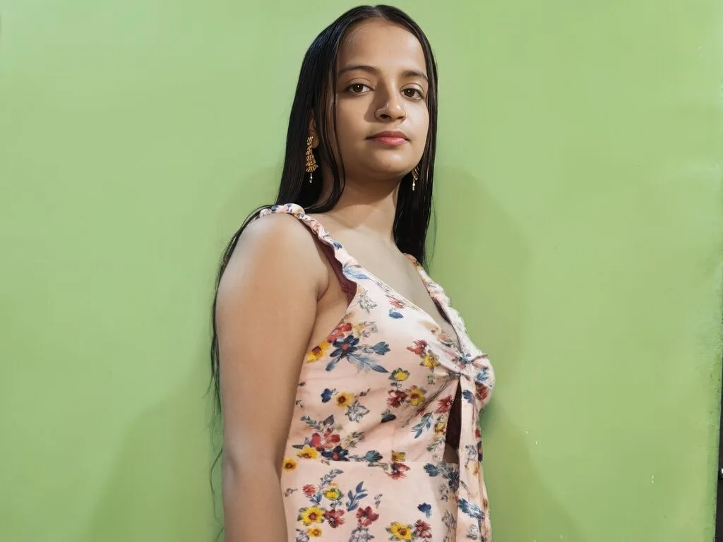 JussyAsma — JussyAsma poses in a floral print sundress against a lime green wall.