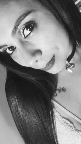 Close-up portrait of a woman with long dark hair wearing a black choker and lace top in a moody black and white style.