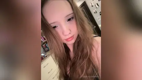 LaritaLudemann looks toward the camera with long brown hair falling over her shoulders in a close-up shot.